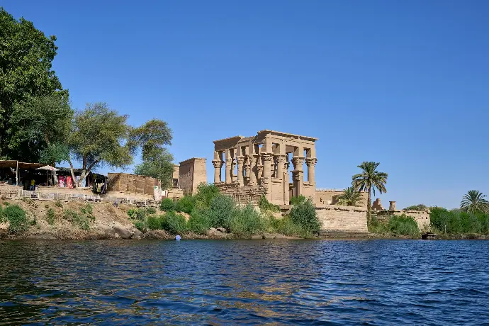 a large building sitting on top of a cliff next to a body of water