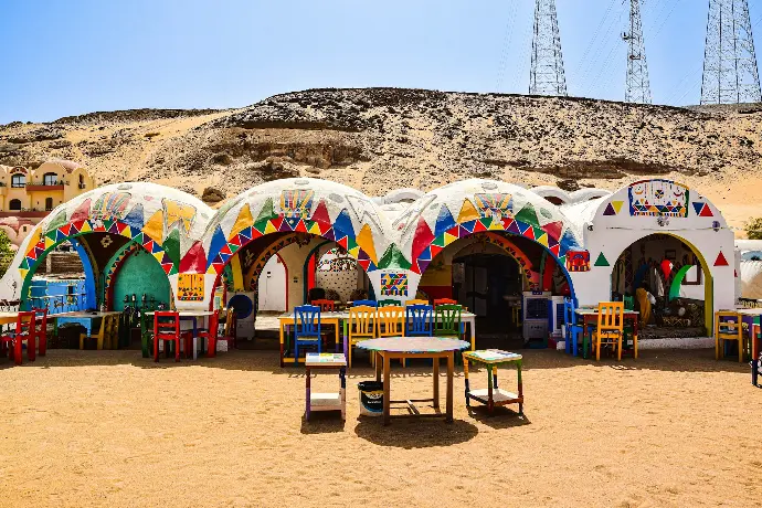 a group of colorful buildings with a hill in the background