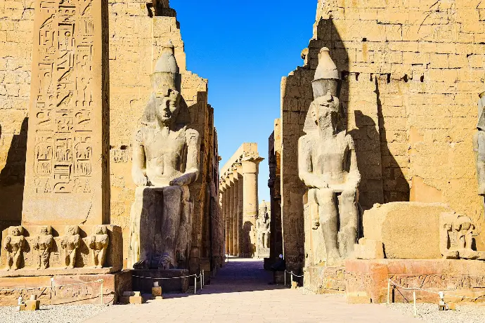 the entrance to an ancient egyptian temple with statues