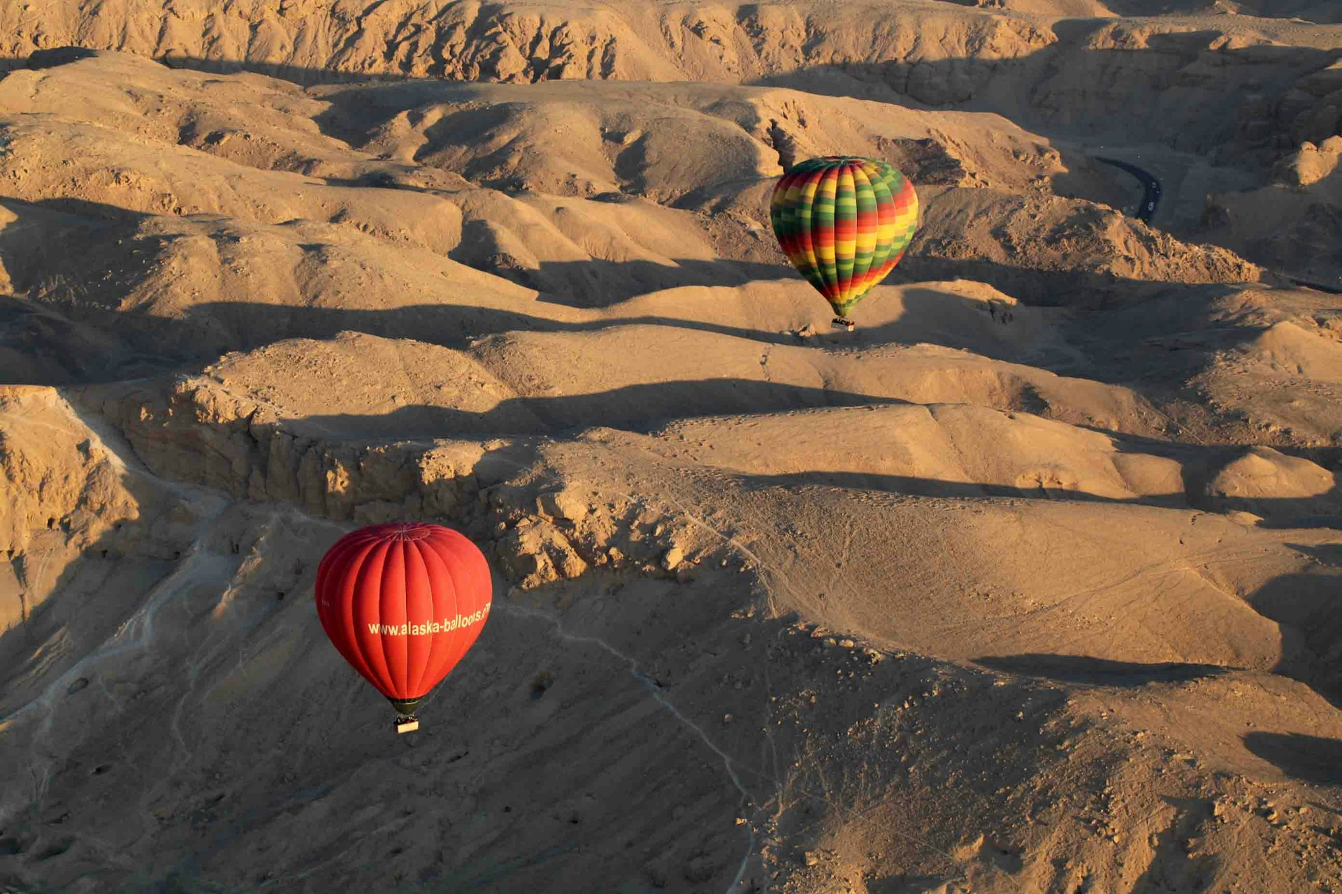 red yellow and green hot air balloon on brown sand